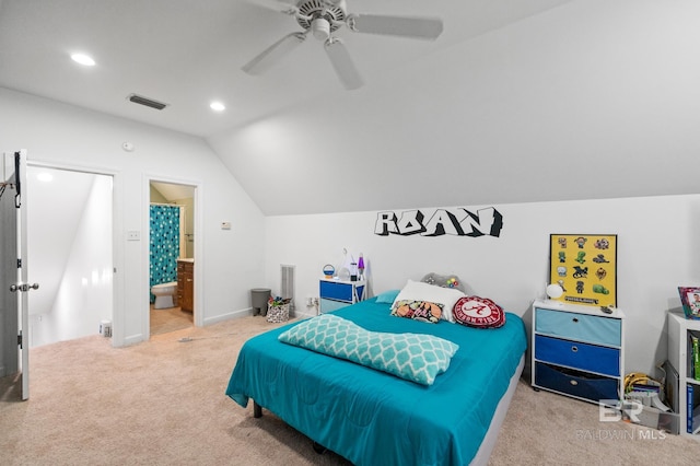 carpeted bedroom with vaulted ceiling, ceiling fan, and ensuite bath