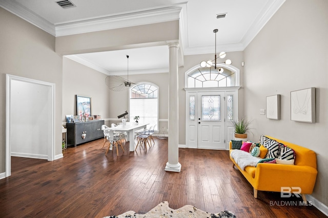 foyer with dark wood-type flooring, ornamental molding, and ornate columns