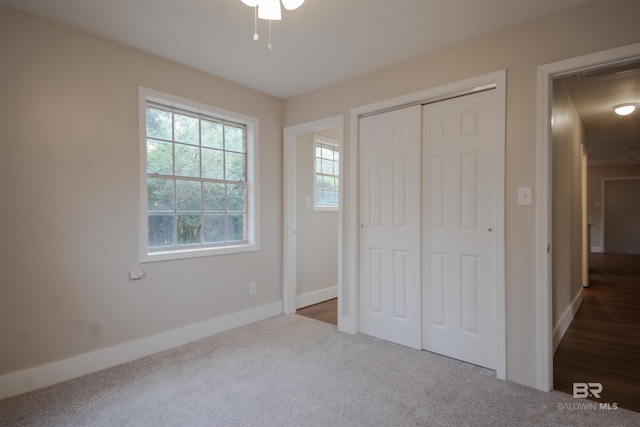 unfurnished bedroom featuring dark colored carpet and a closet