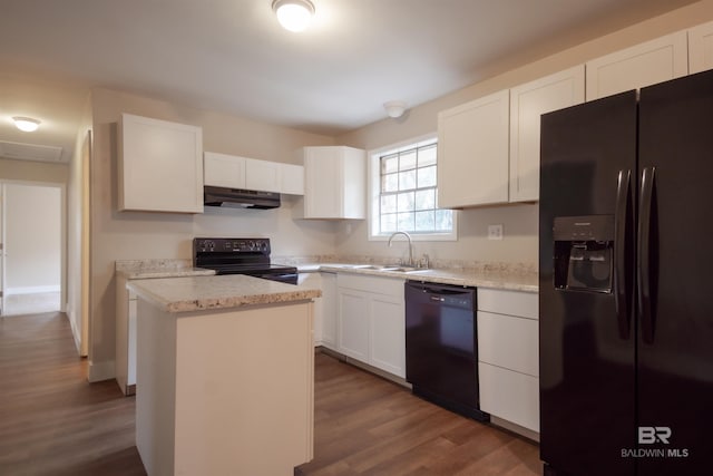 kitchen featuring dark hardwood / wood-style floors, black appliances, white cabinets, a center island, and light stone counters