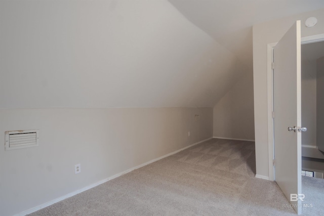 bonus room with light carpet and vaulted ceiling