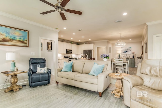 living room with ceiling fan, ornamental molding, and light hardwood / wood-style flooring