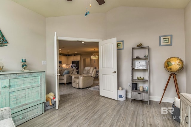 living room featuring hardwood / wood-style flooring, vaulted ceiling, and ceiling fan