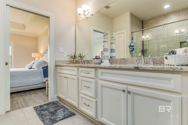 bathroom with tile patterned flooring, crown molding, vanity, and walk in shower