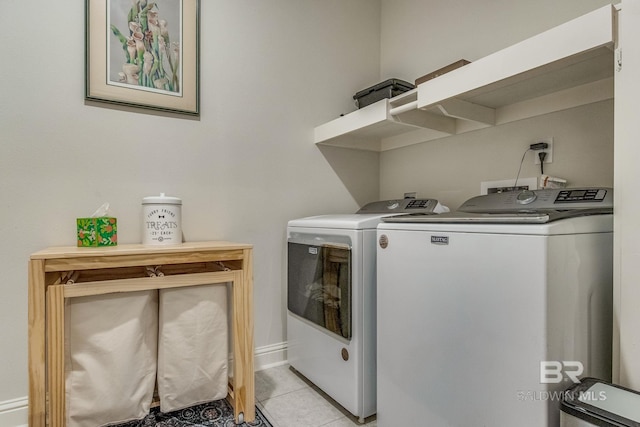 laundry area with washer and dryer and light tile patterned floors