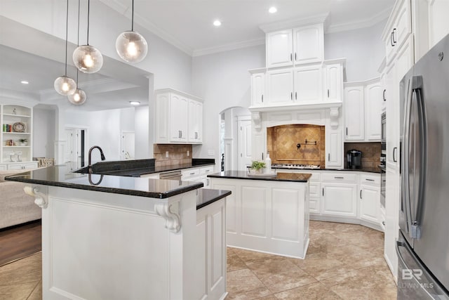 kitchen featuring stainless steel appliances, white cabinetry, a center island, and backsplash