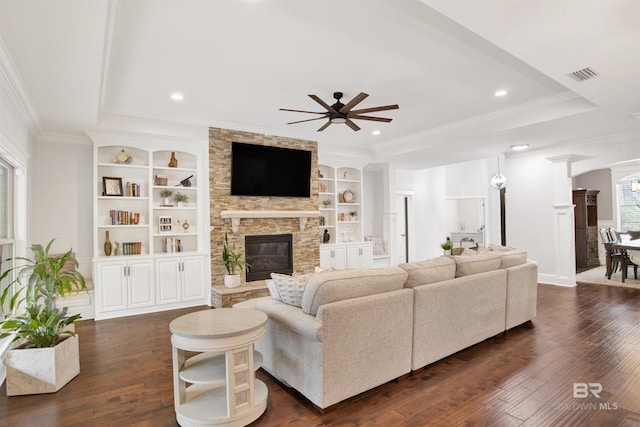 living room featuring dark wood-type flooring, a wealth of natural light, ceiling fan, and built in shelves