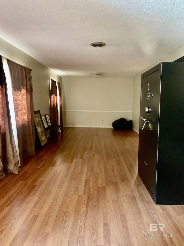 empty room with light hardwood / wood-style flooring and a textured ceiling