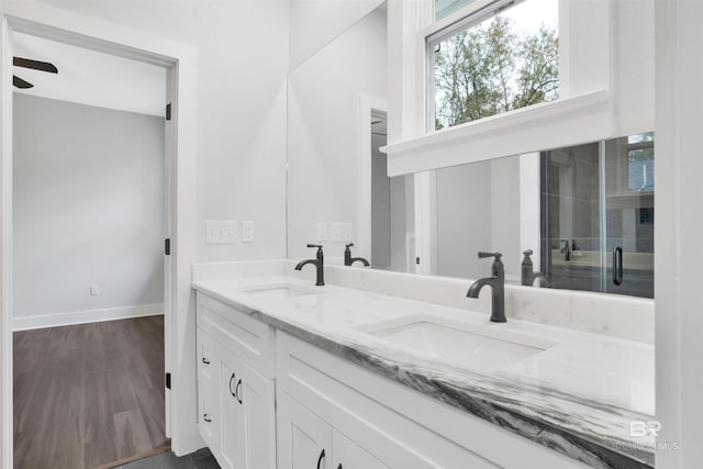 bathroom featuring hardwood / wood-style flooring, vanity, and walk in shower