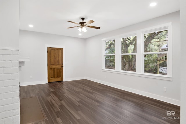 unfurnished living room with dark wood-type flooring, plenty of natural light, and ceiling fan