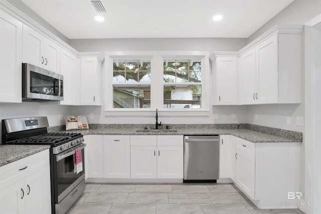 kitchen featuring appliances with stainless steel finishes, sink, and white cabinets