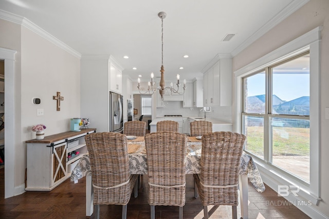 dining area with a healthy amount of sunlight, sink, a mountain view, and a chandelier