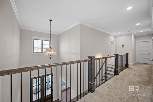 hall featuring carpet floors, crown molding, and a chandelier