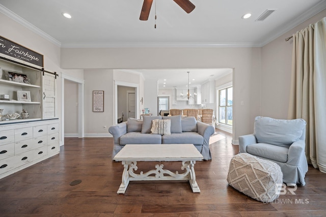 living room with dark wood-type flooring, ceiling fan with notable chandelier, and ornamental molding