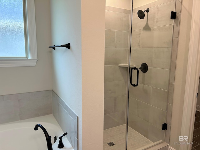 bathroom featuring shower with separate bathtub