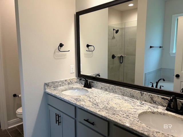 bathroom featuring a shower with door, vanity, and toilet