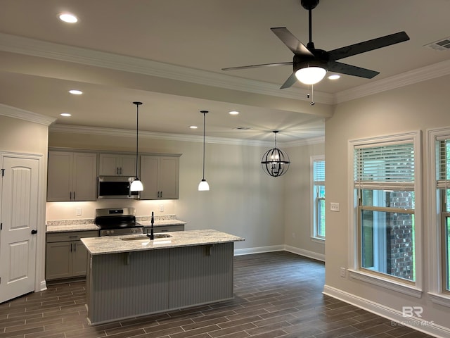 kitchen featuring sink, appliances with stainless steel finishes, gray cabinetry, light stone counters, and an island with sink