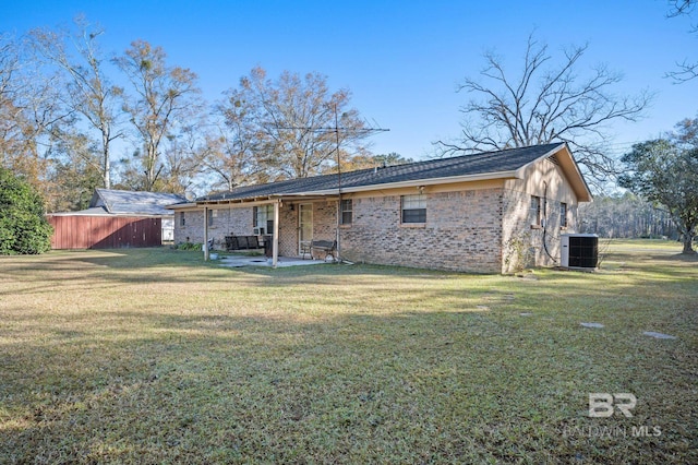 back of property with a yard, a patio, and central air condition unit