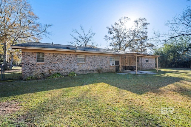 rear view of property with a yard and a patio area