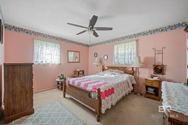 bedroom featuring light colored carpet, a textured ceiling, and ceiling fan