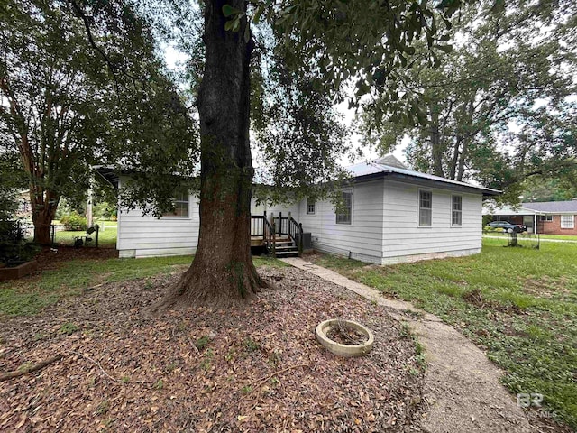 view of side of property featuring a lawn and a deck