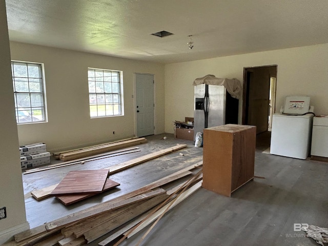 interior space featuring hardwood / wood-style floors, a textured ceiling, and washer / clothes dryer