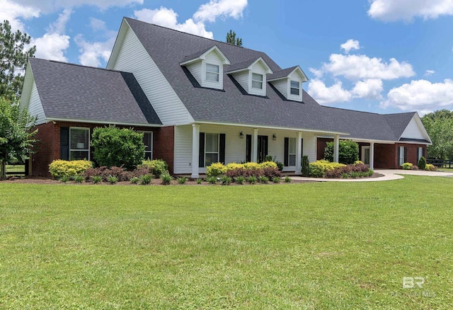 26506 Big Grant Way, Robertsdale, AL 36567 - new england style home featuring brick siding, a front yard, a shingled roof, and covered porch