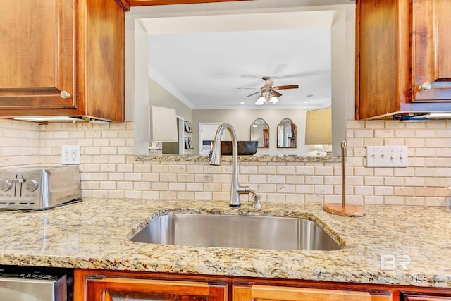26506 Big Grant Way, Robertsdale, AL 36567 - kitchen with a ceiling fan, light stone counters, tasteful backsplash, ornamental molding, and brown cabinets