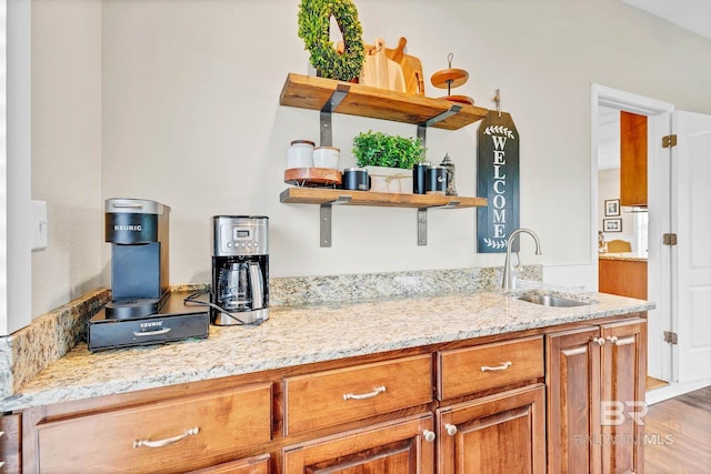 26506 Big Grant Way, Robertsdale, AL 36567 - kitchen featuring brown cabinets, light stone counters, light wood finished floors, and open shelves