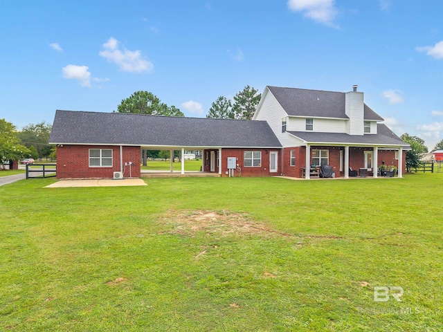 26506 Big Grant Way, Robertsdale, AL 36567 - view of front facade with a patio area, brick siding, a chimney, and roof with shingles