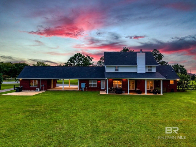 26506 Big Grant Way, Robertsdale, AL 36567 - view of front of home with a chimney, a lawn, a shingled roof, and a patio