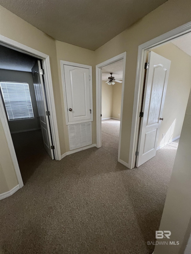 hallway with carpet and a textured ceiling