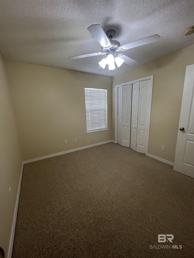 unfurnished bedroom featuring a textured ceiling, carpet floors, and ceiling fan