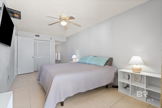 bedroom featuring a closet, visible vents, tile patterned flooring, and a ceiling fan