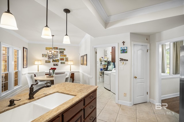 402 Potters Mill Ave, Daphne, AL 36526 - kitchen featuring washer and dryer, a sink, ornamental molding, light tile patterned flooring, and hanging light fixtures