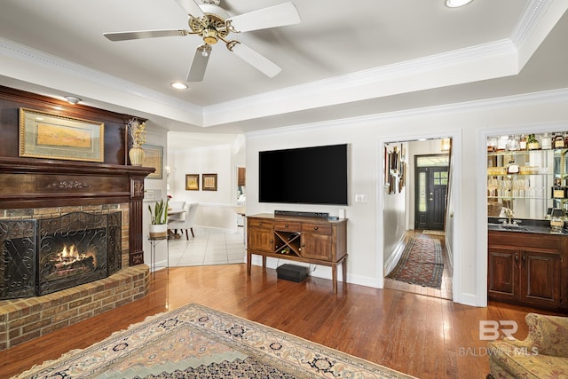 402 Potters Mill Ave, Daphne, AL 36526 - living area with wood finished floors, a raised ceiling, crown molding, ceiling fan, and a fireplace