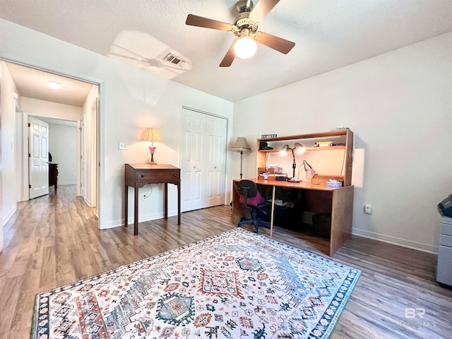 office space with hardwood / wood-style flooring, ceiling fan, and a textured ceiling