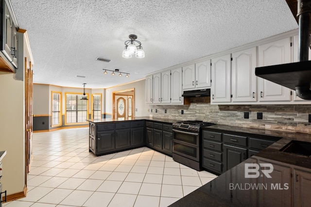 kitchen featuring tasteful backsplash, a textured ceiling, light tile patterned floors, double oven range, and white cabinetry