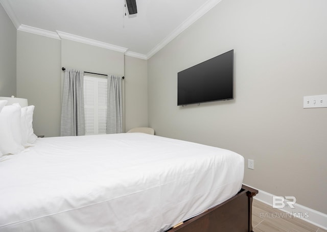 bedroom featuring ceiling fan, baseboards, ornamental molding, and wood finished floors