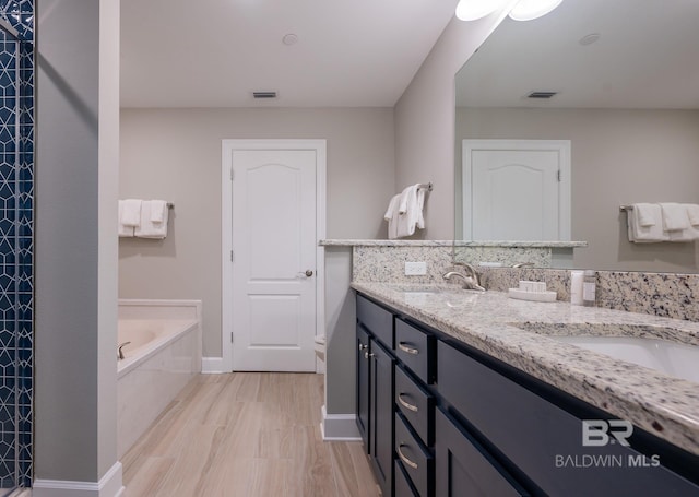 full bathroom with visible vents, double vanity, a sink, and a bath