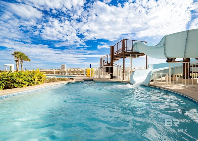 community pool with a water slide and stairs
