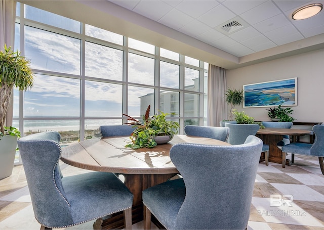 dining space with visible vents, plenty of natural light, and a water view