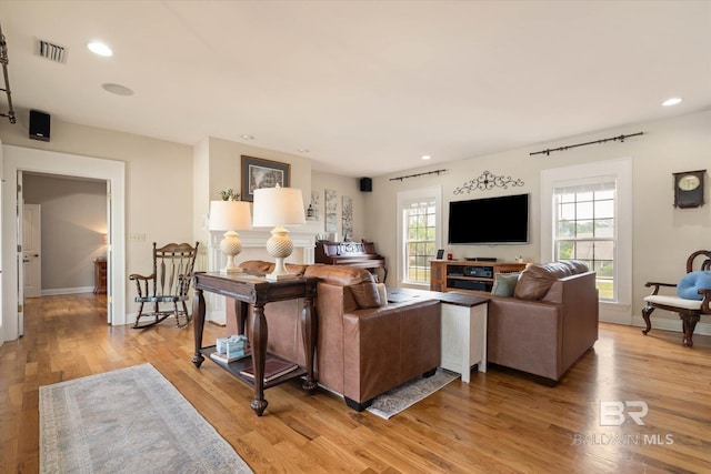 living room with visible vents, light wood-type flooring, recessed lighting, and plenty of natural light