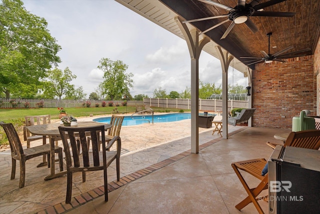 view of pool with a fenced backyard, a patio, outdoor dining area, a ceiling fan, and a lawn