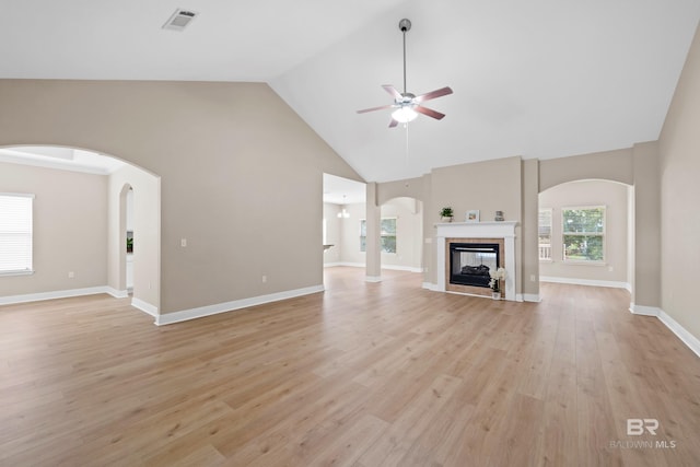 unfurnished living room featuring ceiling fan, light hardwood / wood-style floors, a multi sided fireplace, and high vaulted ceiling