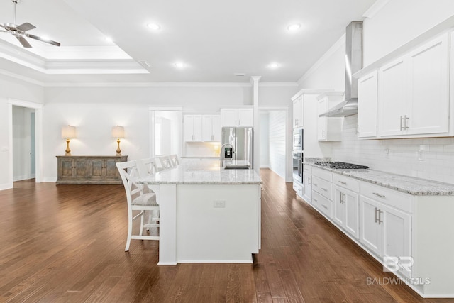 360 Nandina Loop, Fairhope, AL 36532 - kitchen featuring stainless steel appliances, wall chimney range hood, crown molding, decorative backsplash, and a kitchen breakfast bar