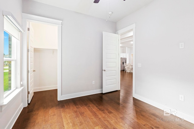 360 Nandina Loop, Fairhope, AL 36532 - unfurnished bedroom with wood finished floors, a walk in closet, a closet, baseboards, and stainless steel fridge with ice dispenser