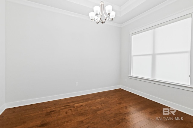 empty room with an inviting chandelier, hardwood / wood-style floors, and ornamental molding