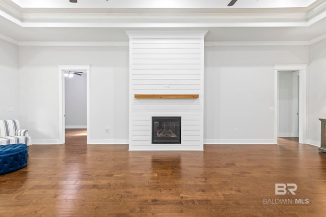 unfurnished living room featuring ceiling fan, wood-type flooring, a fireplace, and ornamental molding