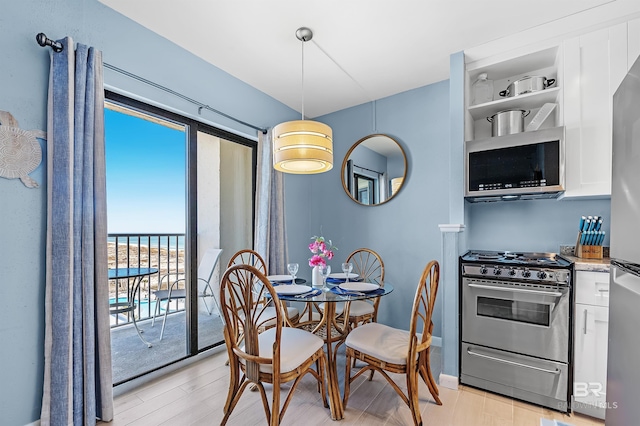 dining area featuring a water view and light wood-type flooring